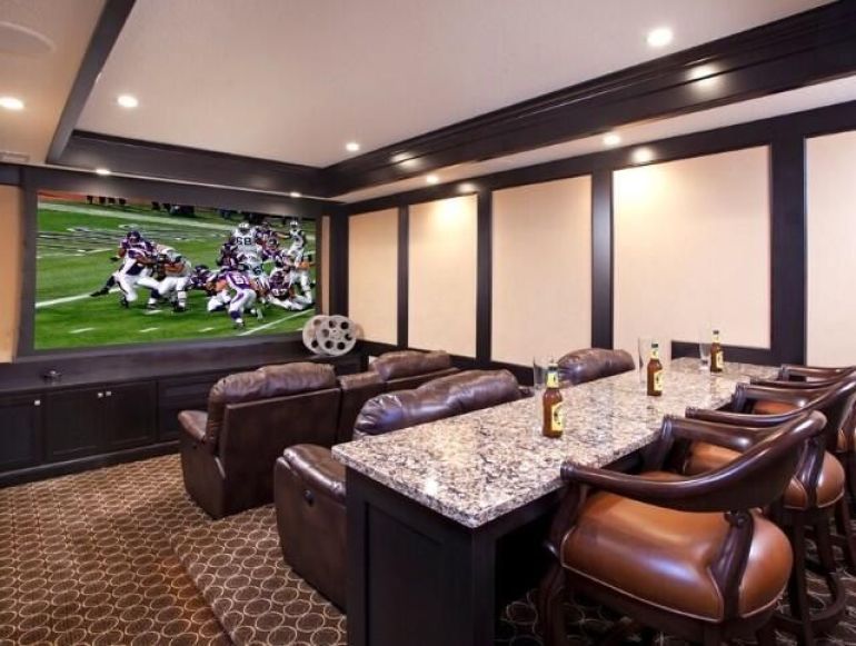 A cinema screen TV, leather recliners and a bar - man cave bliss
