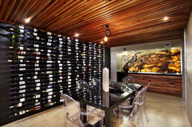 Wine cellar with dining table and ghost chairs